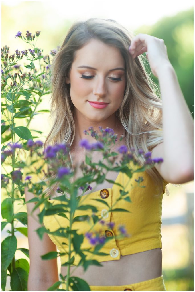 Senior Pictures in Wichita KS girl in yellow dress with purple wildflowers - Pawnee Prairie Park Wichita, KS