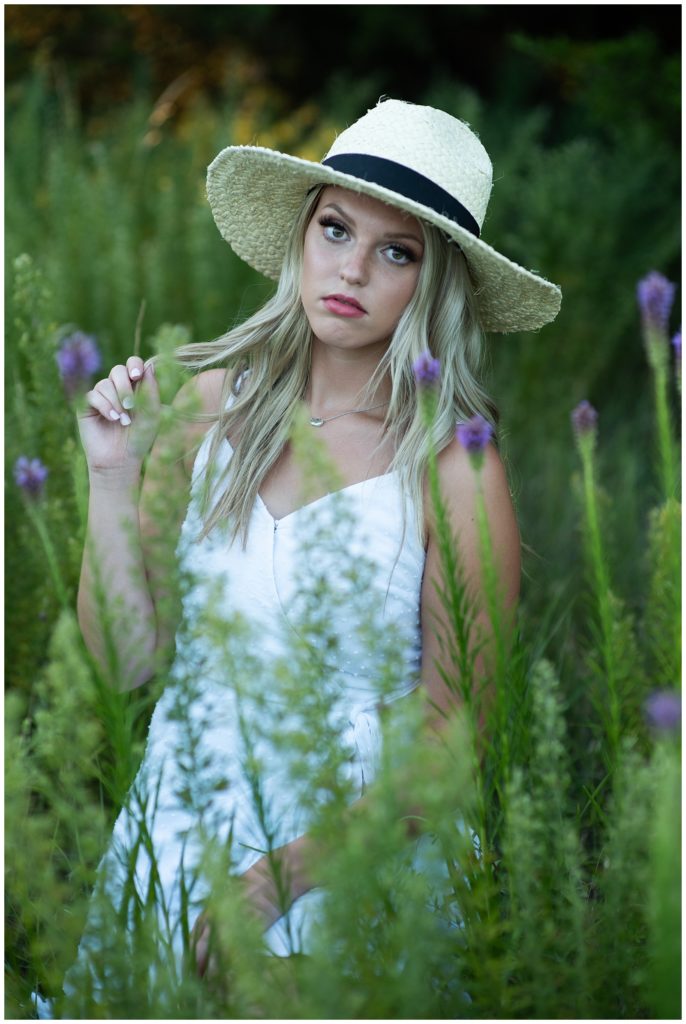 senior girl hat and white dress in flower field