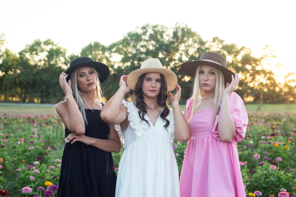 Girls in hats in zinnia field 
Wichita, KS Senior pictures