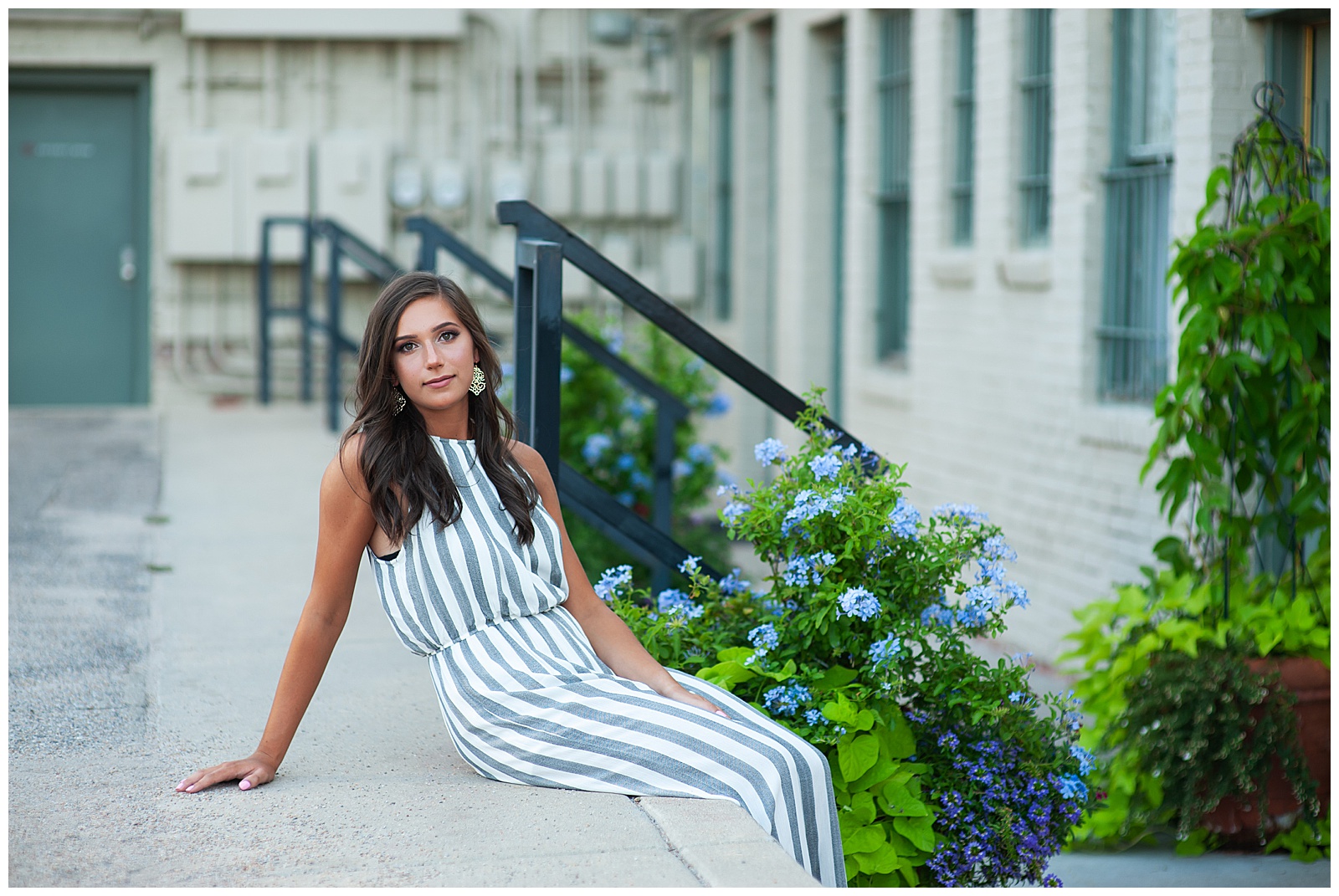 high school senior sitting in front building and plants senior pictures Kim Stiffler Photography