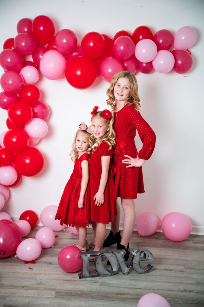 Valentine's Mini Session Wichita, KS three girls in red dresses with balloons