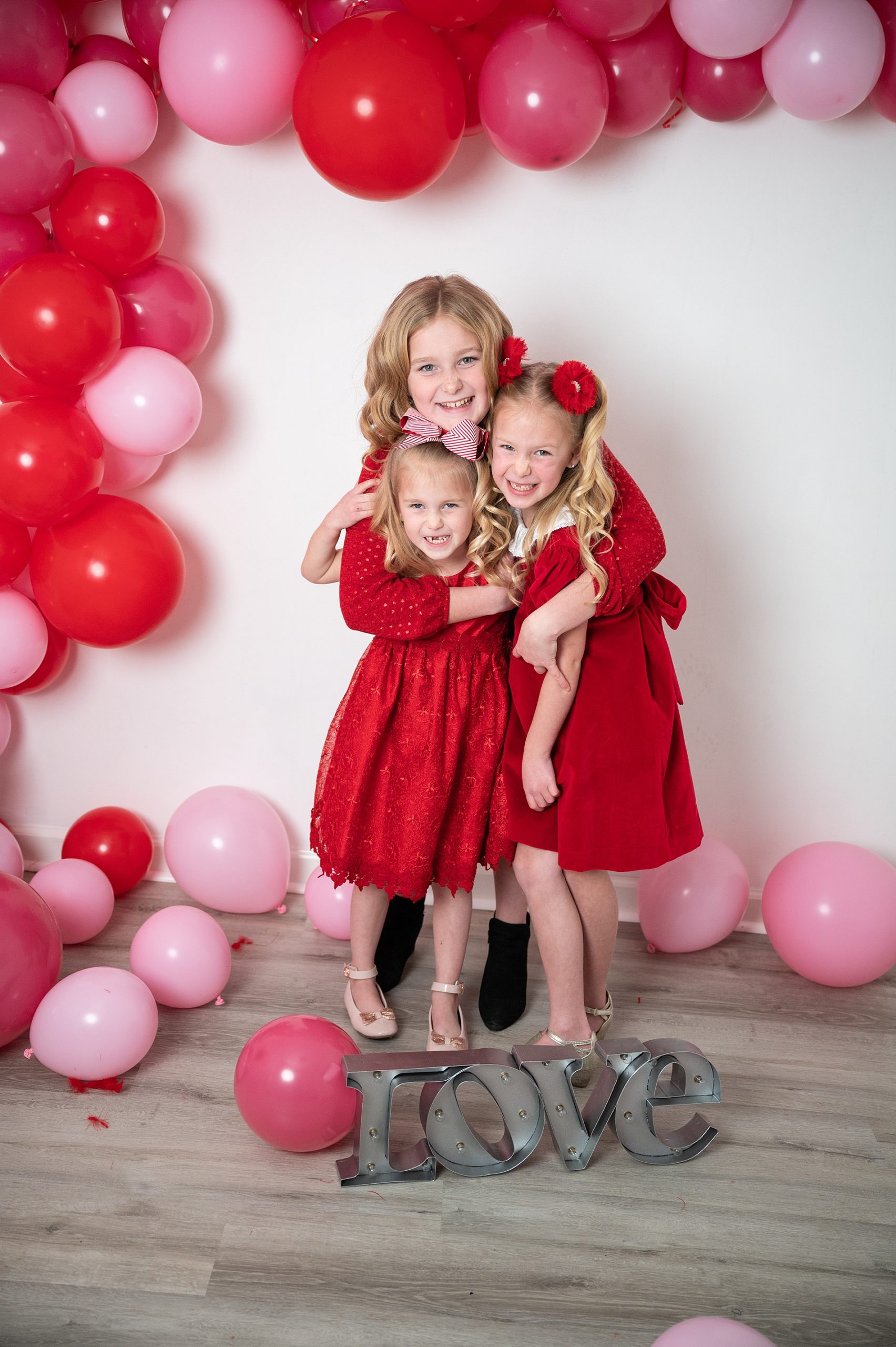 Valentine Mini Session Wichita, KS three girls in red dresses with balloons