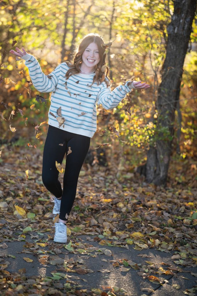 teenage girl in fall leaves photoshoot