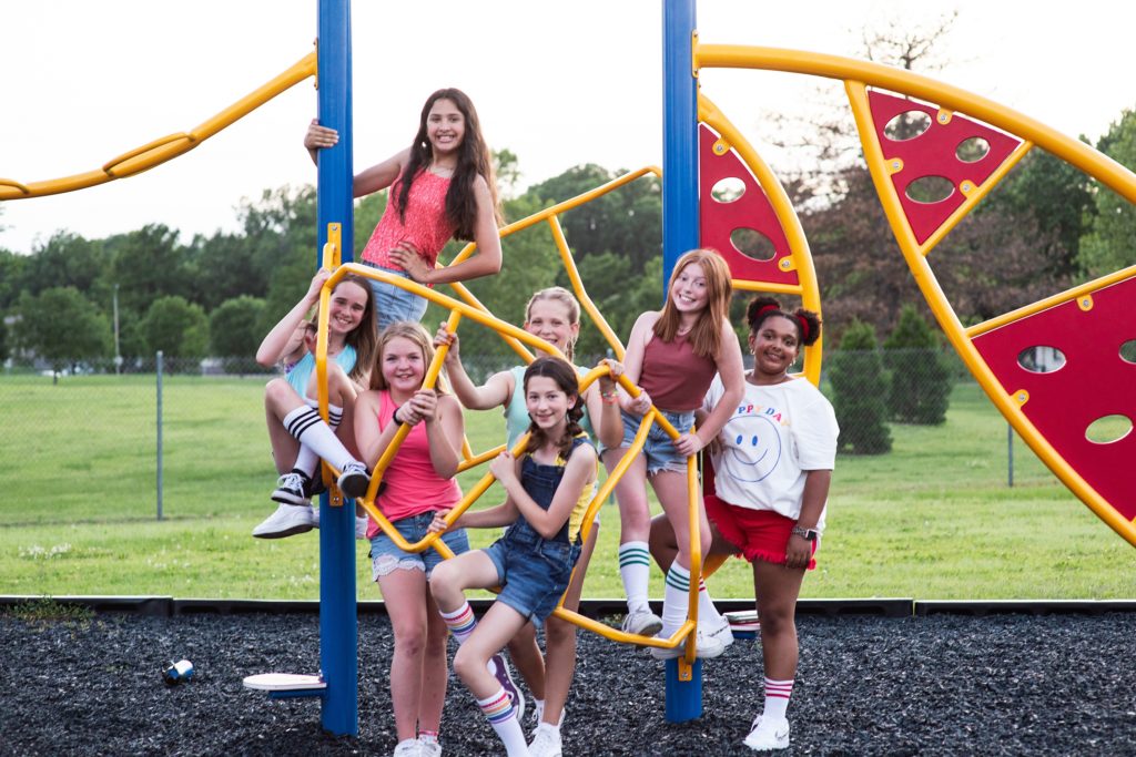 group photo of teens on playground equipment