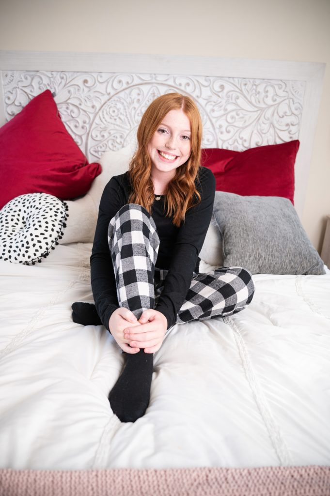 girl in black pajamas on white bed sleepover