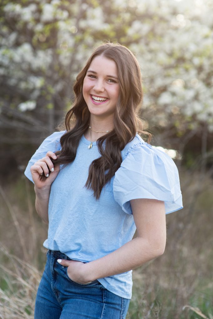 high school senior girl taking pictures in the spring with blue top.  Kim Stiffler Photography Senior Portrait photographer