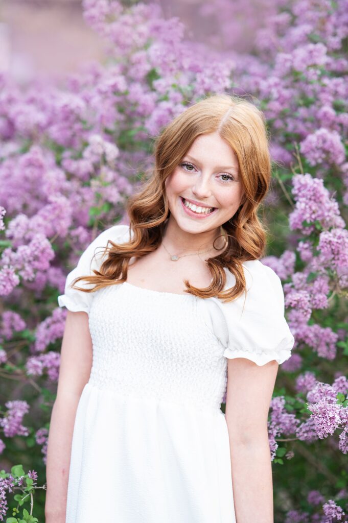 red haired girl in white dress with spring flowers photography session