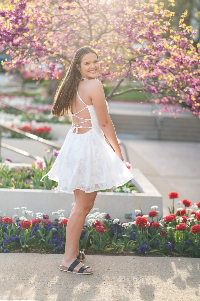 spring senior pictures flowering trees and tulips girl in white dress