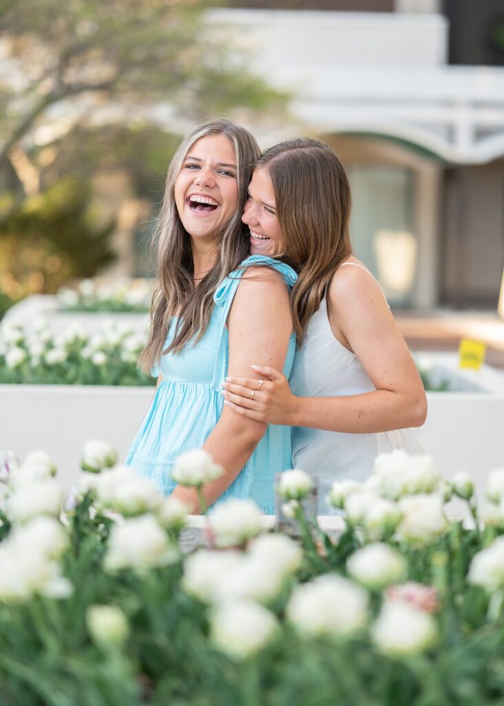 twin high school seniors in spring dresses posing in front of tulips