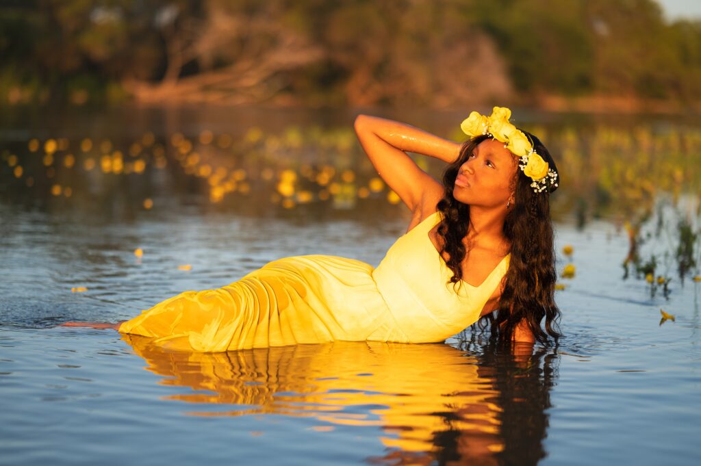 high school senior girl in yellow dress and flower crown in water senior pictures