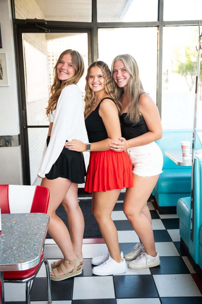 senior girls at Spangles participating in fun photoshoot dressed in red, white, black.