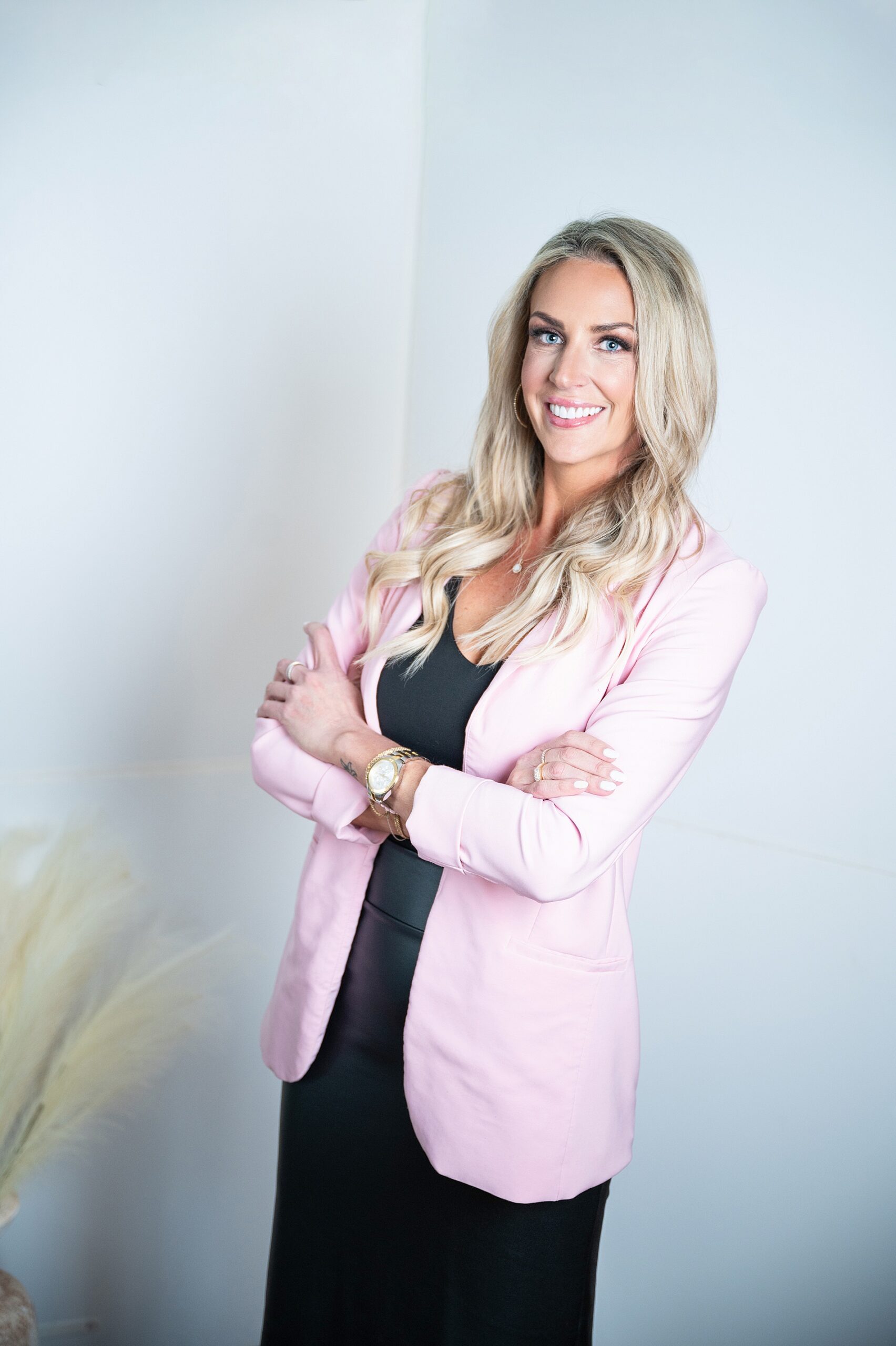 image of a successful woman entrepreneur blonde hair pink blazer, and a black dress