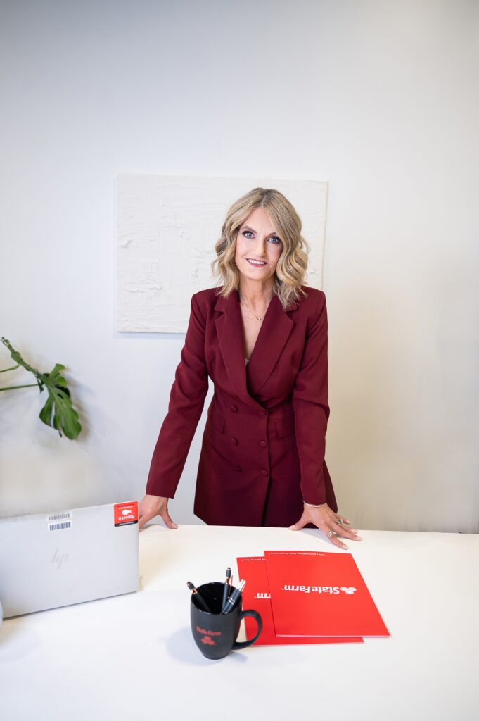 business woman in maroon suit leaning over desk