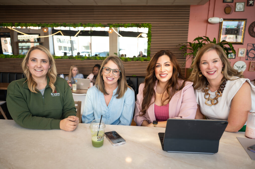 Four business women working in a coffee shop